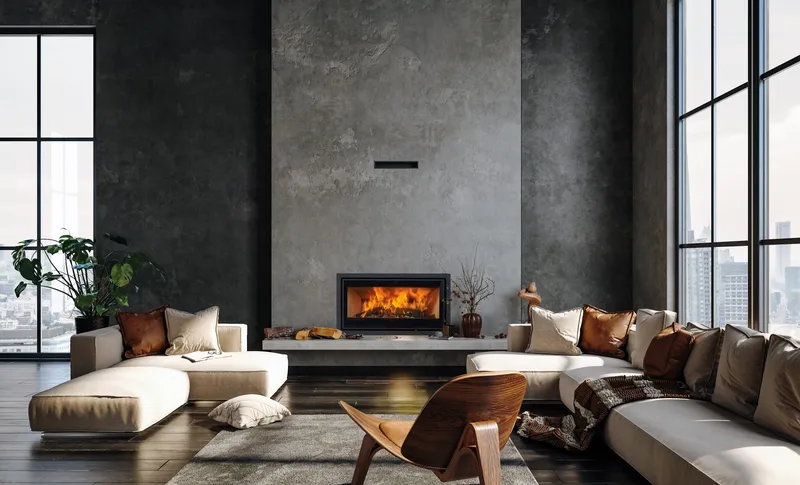 Insert Jidé Pure 77 encastré dans un mur en béton gris, dans un grand séjour avec canapés et fauteuil en bois