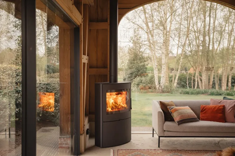 Poêle à bois Saey Fura Evo High, installé près d’une baie vitrée
